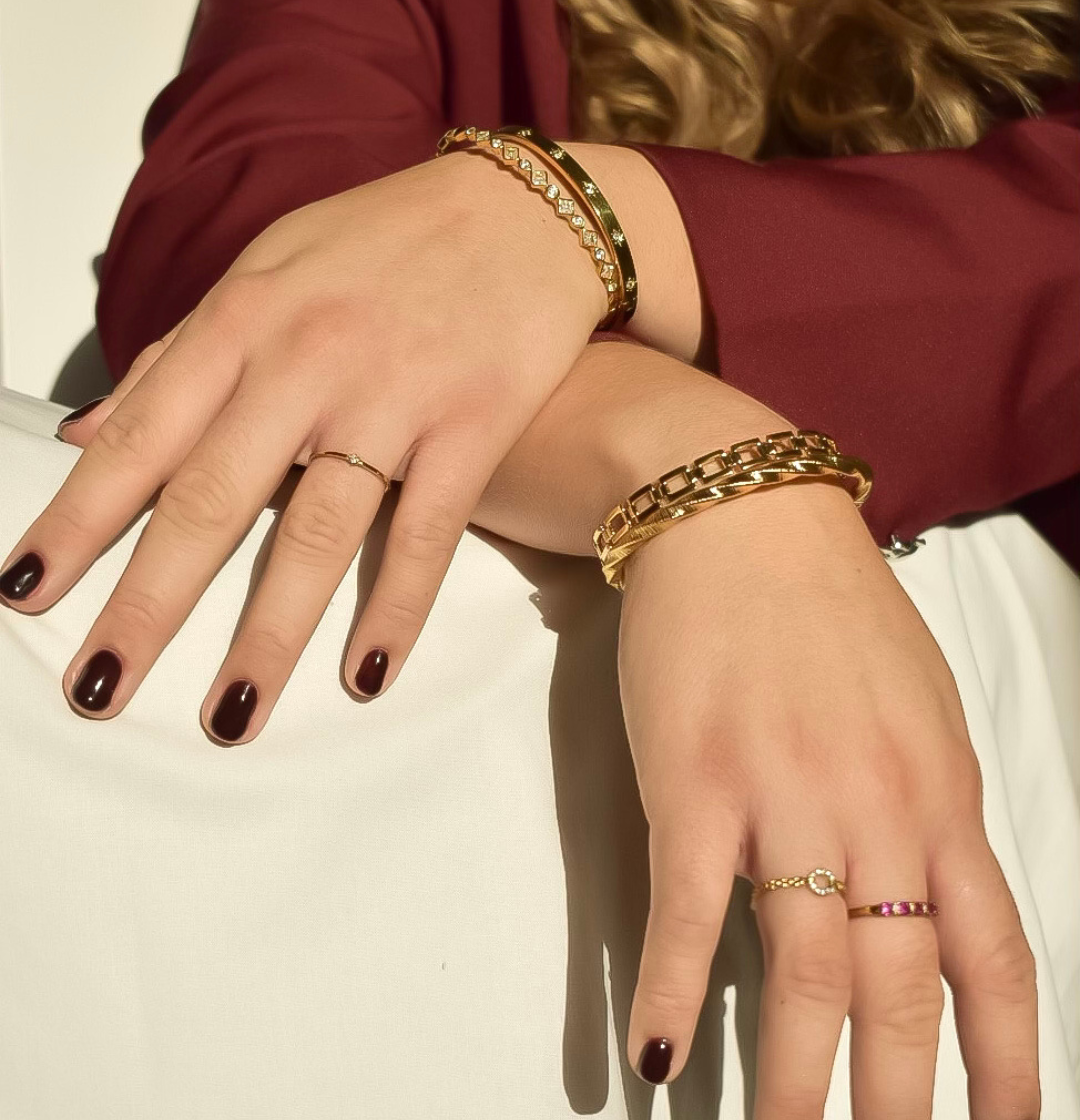 Close-up van de Ava armband van stainless steel met een elegant gedraaid design, glanzend en stijlvol om de pols gedragen, hypoallergeen en waterdicht.
