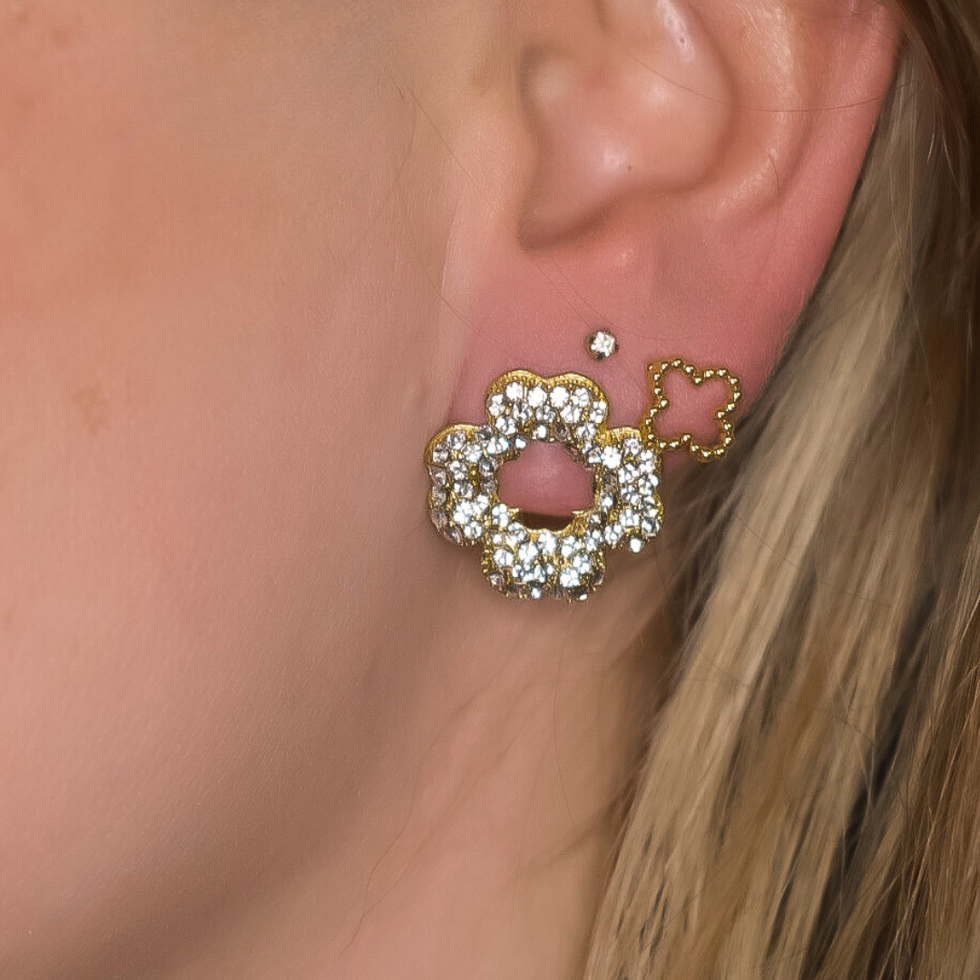 Close-up van de Bloom Studs oorbellen in bloemvorm, gevuld met zilveren stras steentjes, gemaakt van stainless steel, hypoallergeen, waterproof en verkleuren niet.