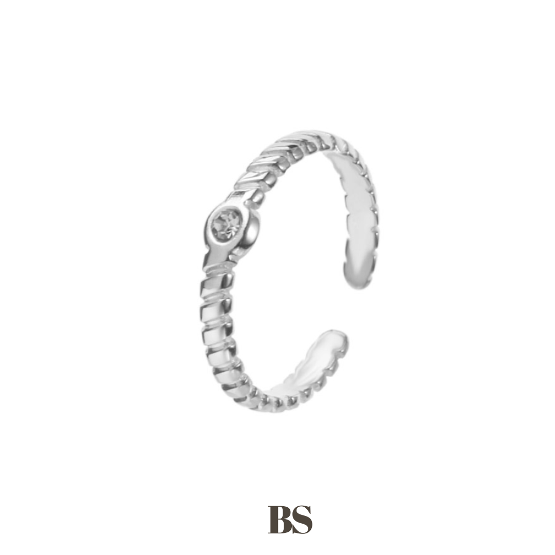 Close-up van de Luna Ring, een subtiele stainless steel ring met een twist detail en een zilveren steentje, verstelbaar naar iedere maat, hypoallergeen, waterdicht en verkleurt niet.